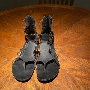 Black flat sandals with zipper up back, gold details